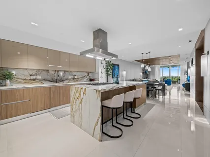 a large kitchen with stainless steel appliances granite countertop a lot of counter space and a sink