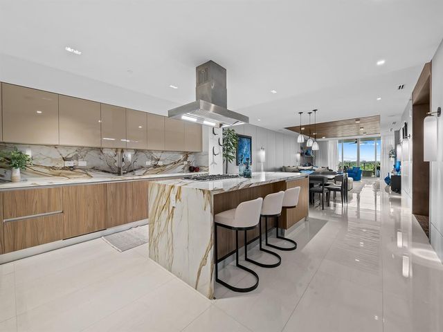 a large kitchen with stainless steel appliances granite countertop a lot of counter space and a sink