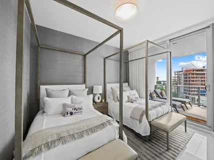 a large bedroom with a bed couch and a large window