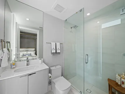 a bathroom with a sink toilet vanity and shower