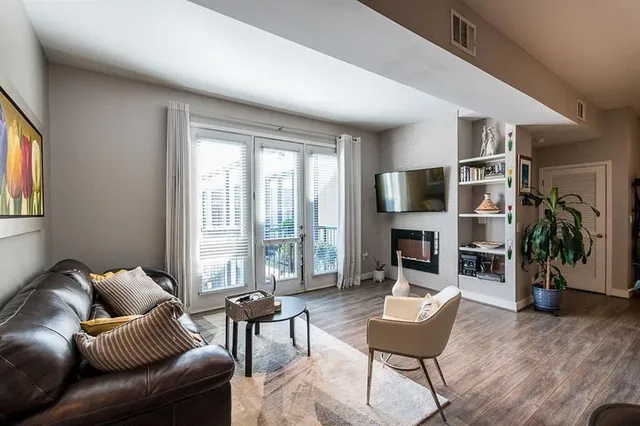 a living room with furniture a fireplace and a large window