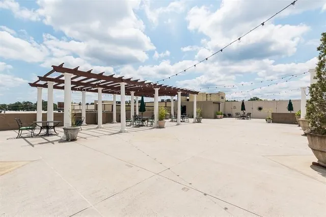 a dining table chairs wooden floor and a view of the kitchen