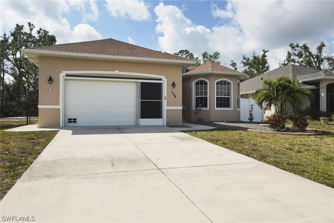 139 Crevalle Road Rotonda West, FL 33947 - Photo 2 of 2 a front view of a house with garden