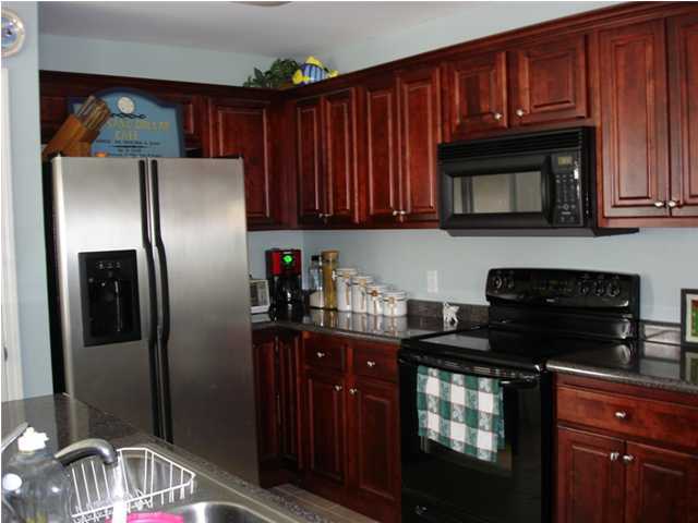 87 Indian Woman Road Santa Rosa Beach, FL 32459 - Photo 5 of 14 a kitchen with granite countertop stainless steel appliances and wooden cabinets