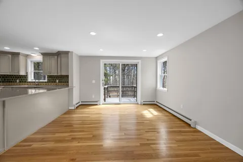 a view of kitchen with granite countertop refrigerator oven sink and white cabinets