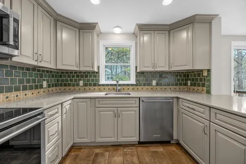 a kitchen with granite countertop a sink and a stove