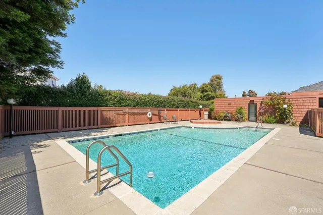 a view of a swimming pool with a patio and a yard