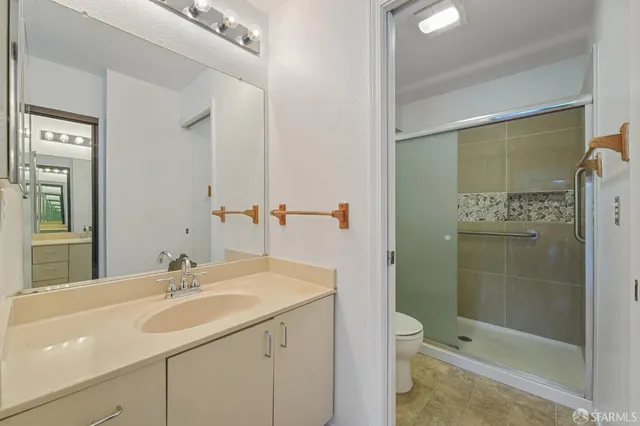 a bathroom with a sink a toilet and shower