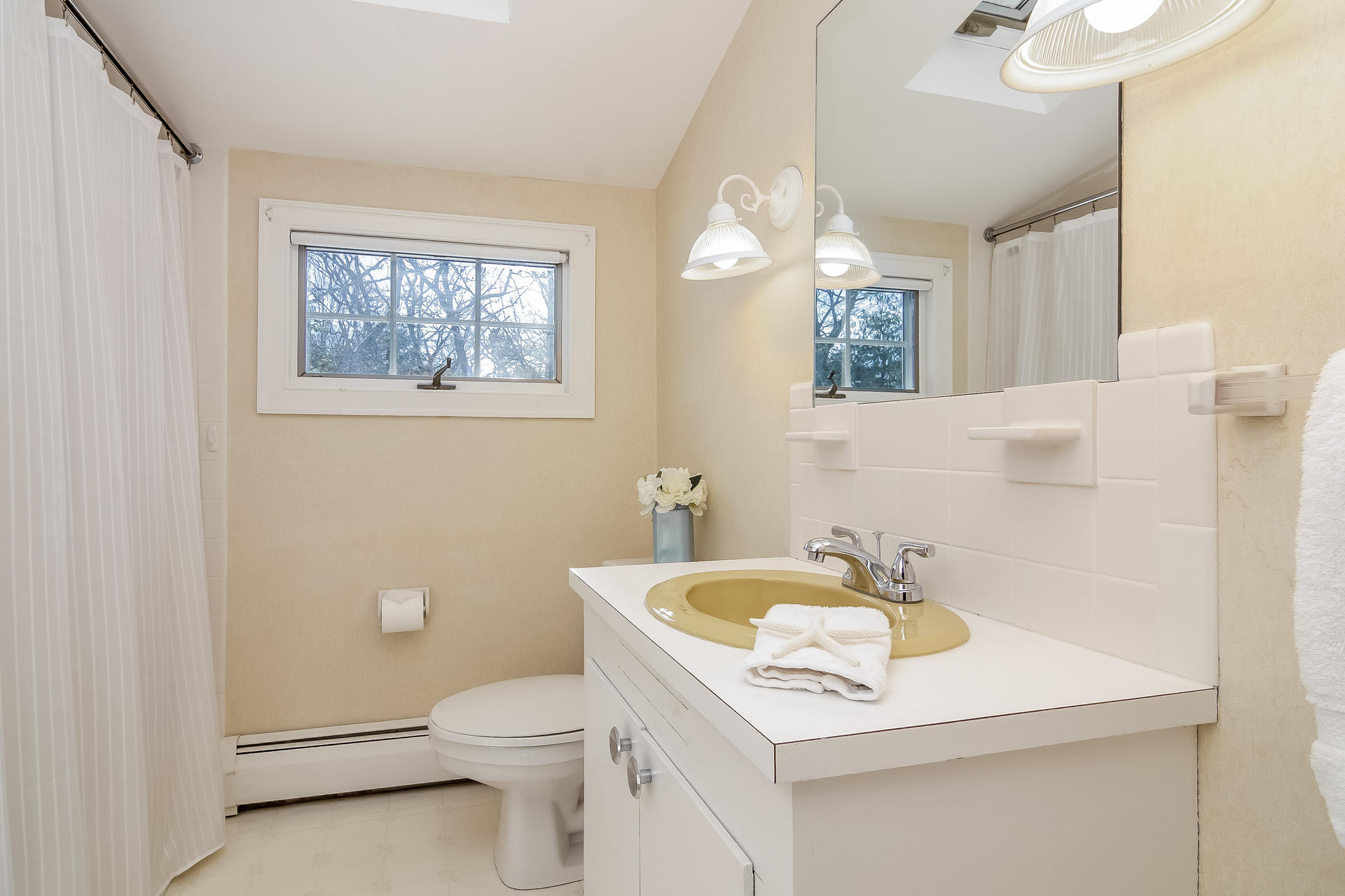 41 Oxner Road Centerville, MA 02632 - Photo 19 of 26 a bathroom with a sink a toilet a mirror and a window