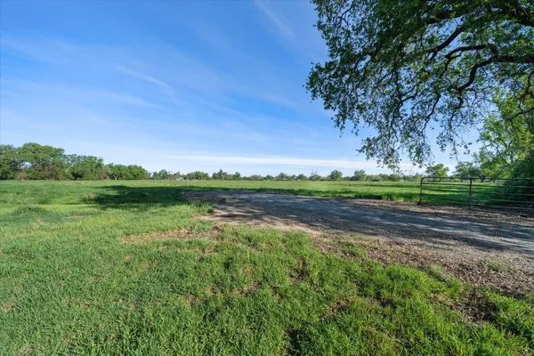 a view of a green field with wooden fence