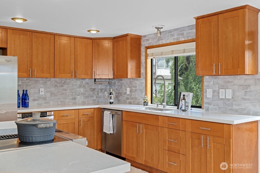 902 7th Avenue South Edmonds, WA 98020 - Photo 12 of 31 a kitchen with stainless steel appliances wooden cabinets a sink and a large window