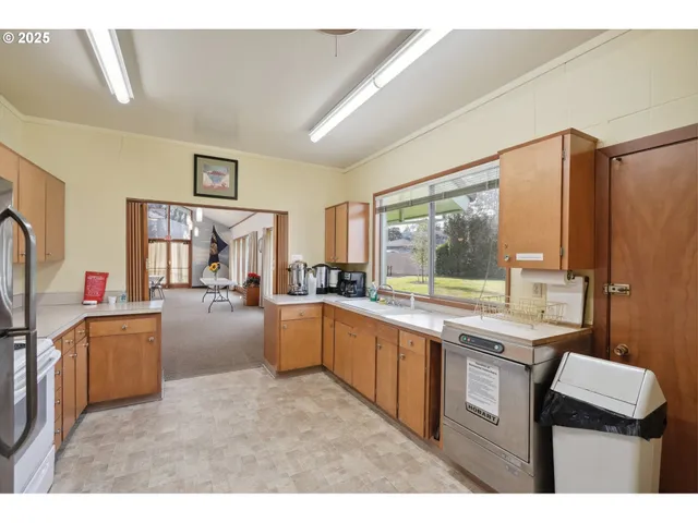 a kitchen with stainless steel appliances kitchen island granite countertop a sink and a refrigerator