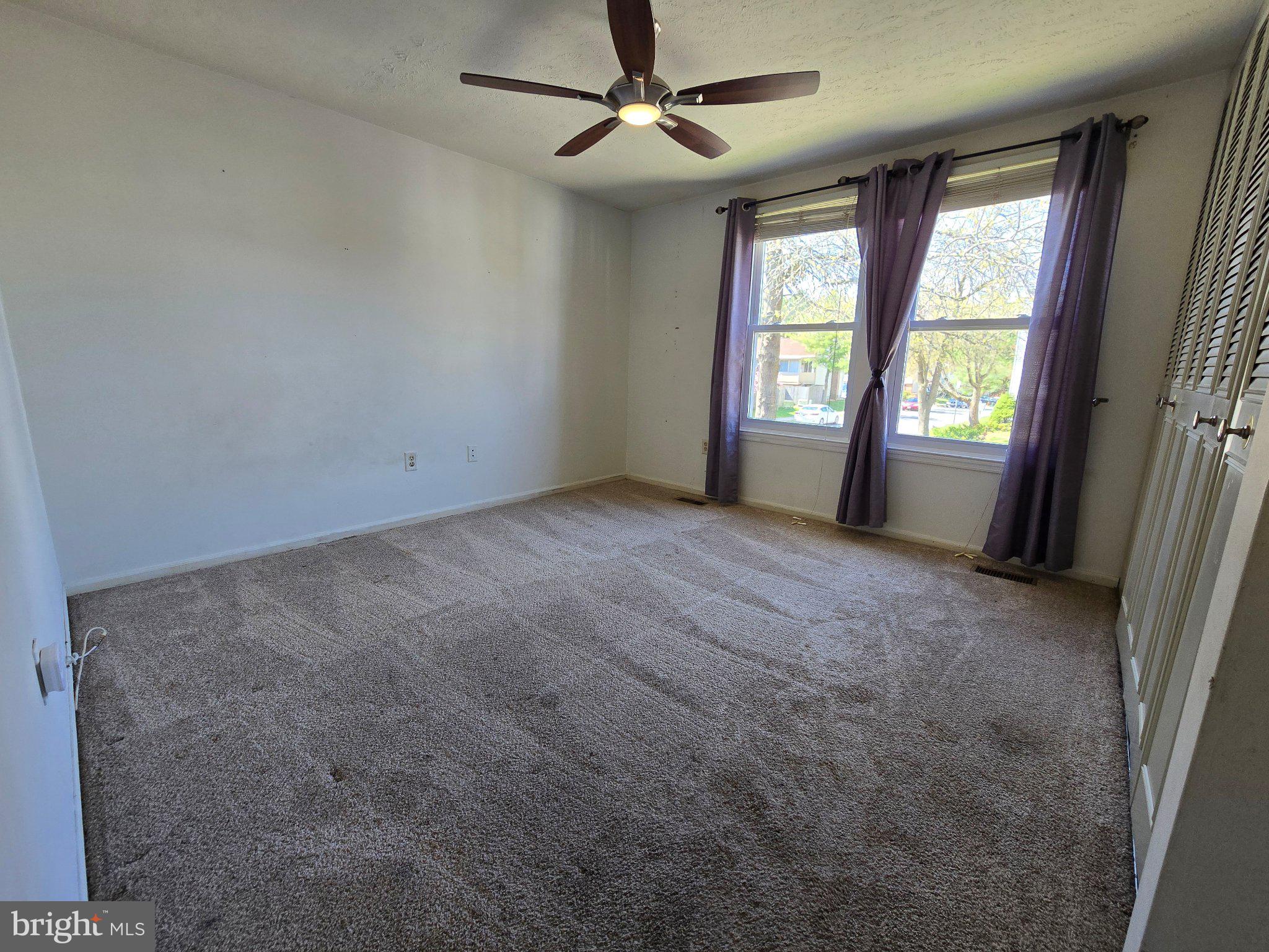 5040 Clifford Road, Unit 5040 Perry Hall, MD 21128 - Photo 10 of 19 en empty room with windows and ceiling fan