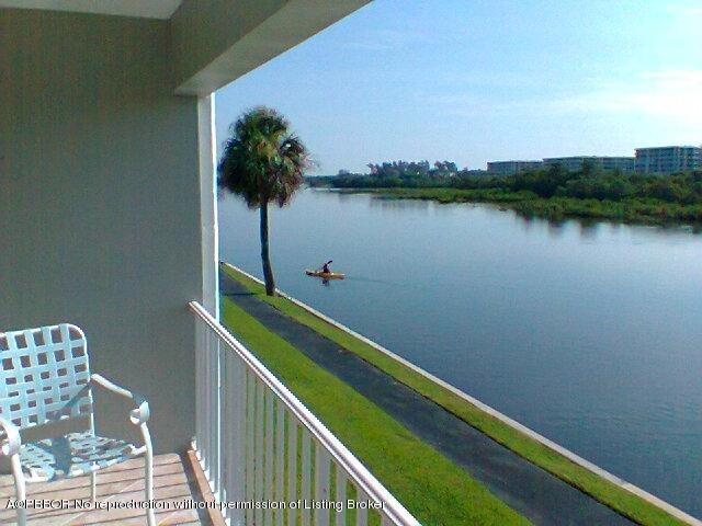 2195 Ibis Isle Road, Unit 5 Palm Beach, FL 33480 - Photo 1 of 12 a view of a lake with wooden stairs and seating space