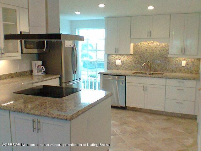 2195 Ibis Isle Road, Unit 5 Palm Beach, FL 33480 - Photo 6 of 12 a kitchen with stainless steel appliances granite countertop a sink a stove and a refrigerator