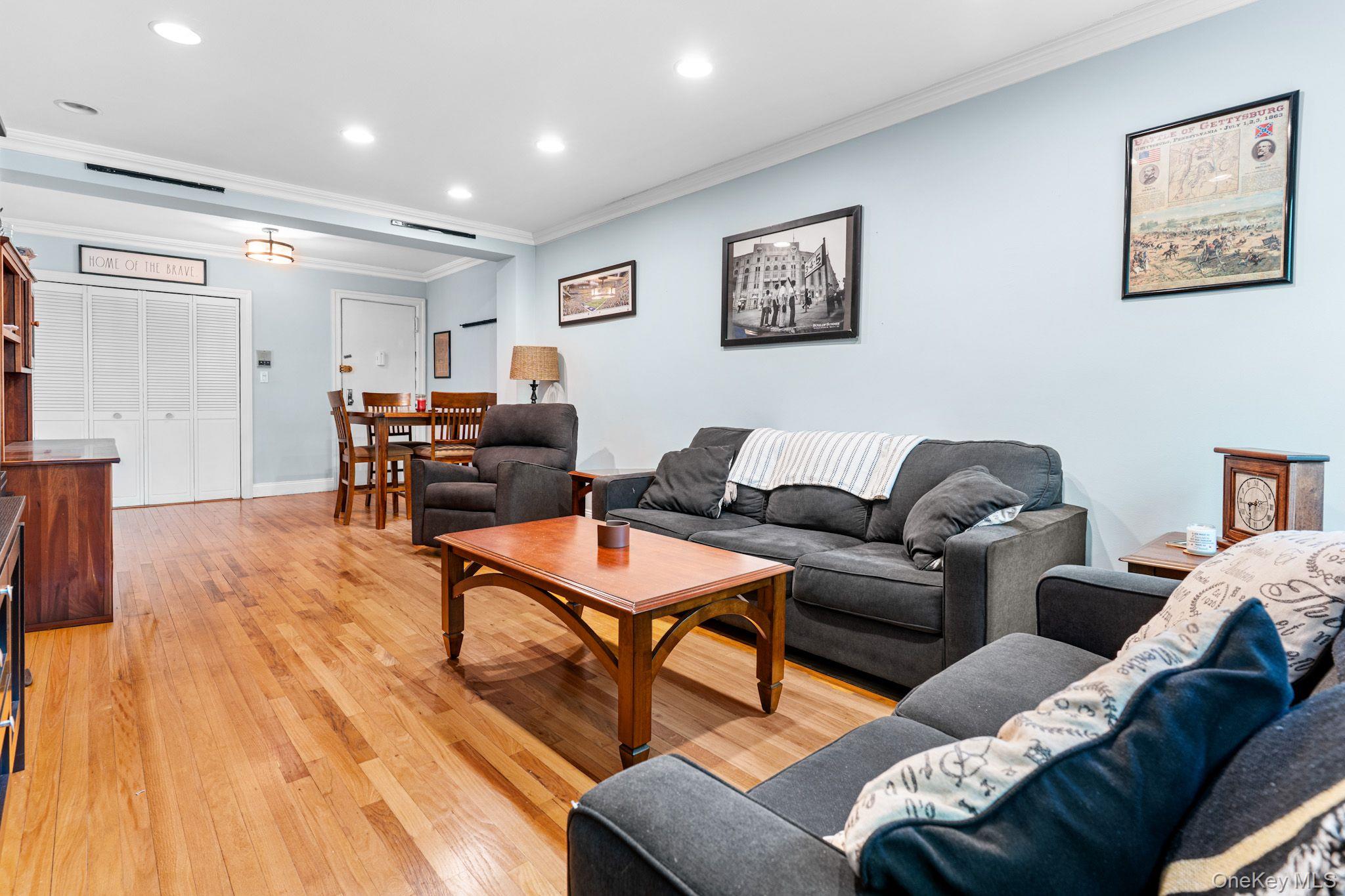 755 Bronx River Road, Unit 4B Bronxville, NY 10708 - Photo 9 of 27 Open-concept living space featuring wood-finish flooring, recessed lighting, crown molding, and multiple windows