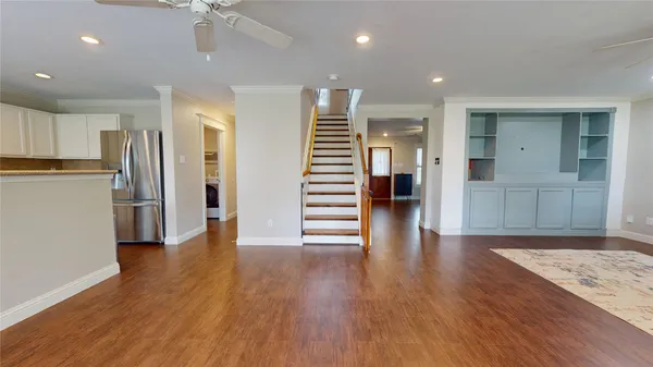 a view of a kitchen with wooden floor and a ceiling fan