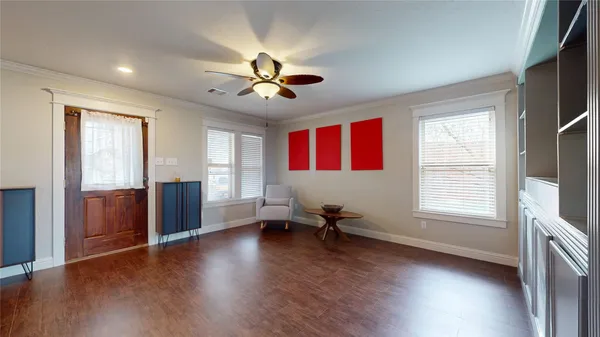 a view of an empty room with a window and wooden floor