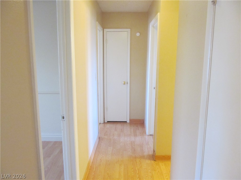 537 Longtree Avenue Henderson, NV 89011 - Photo 14 of 31 This home features a central hallway with inviting wood flooring, connecting various living spaces.
