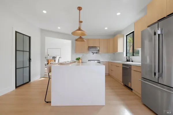 a kitchen with kitchen island a counter top space cabinets and stainless steel appliances