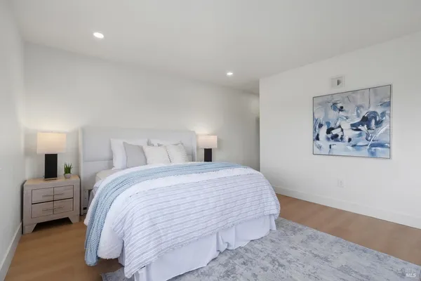 a bedroom with a bed and a painting on the wall