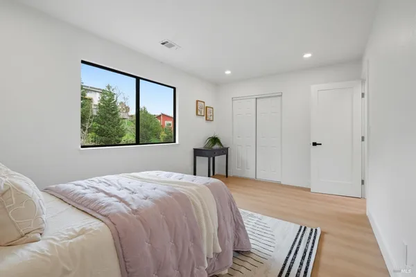 a bed sitting in a spacious bedroom next to a window