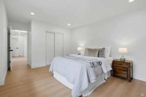 a spacious bedroom with a bed and a lamp