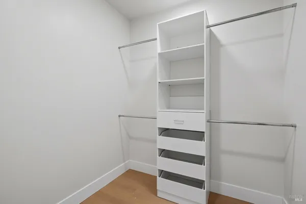 a view of walk in closet with empty racks