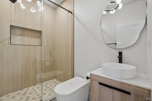a bathroom with a sink a toilet and shower