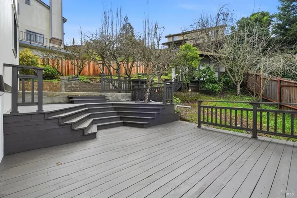 a view of a terrace with wooden fence and trees