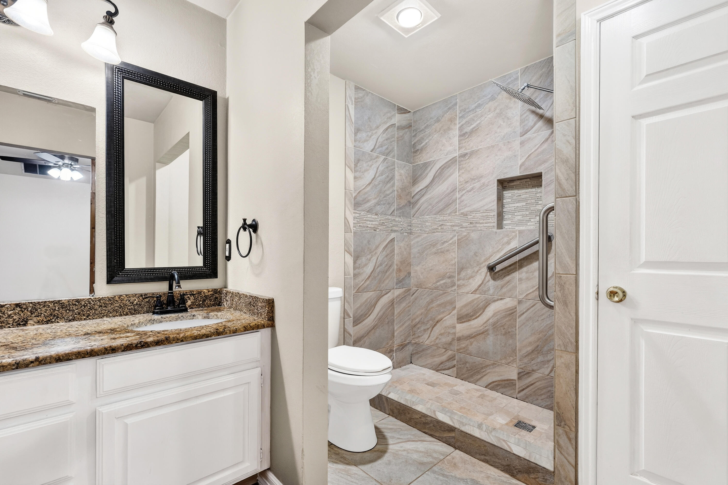 2415 93rd Street Lubbock, TX 79423 - Photo 15 of 24 a bathroom with a granite countertop sink toilet and shower