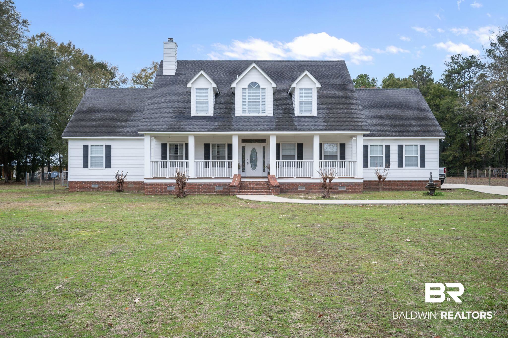 Cape cod-style house featuring a front lawn and a porch