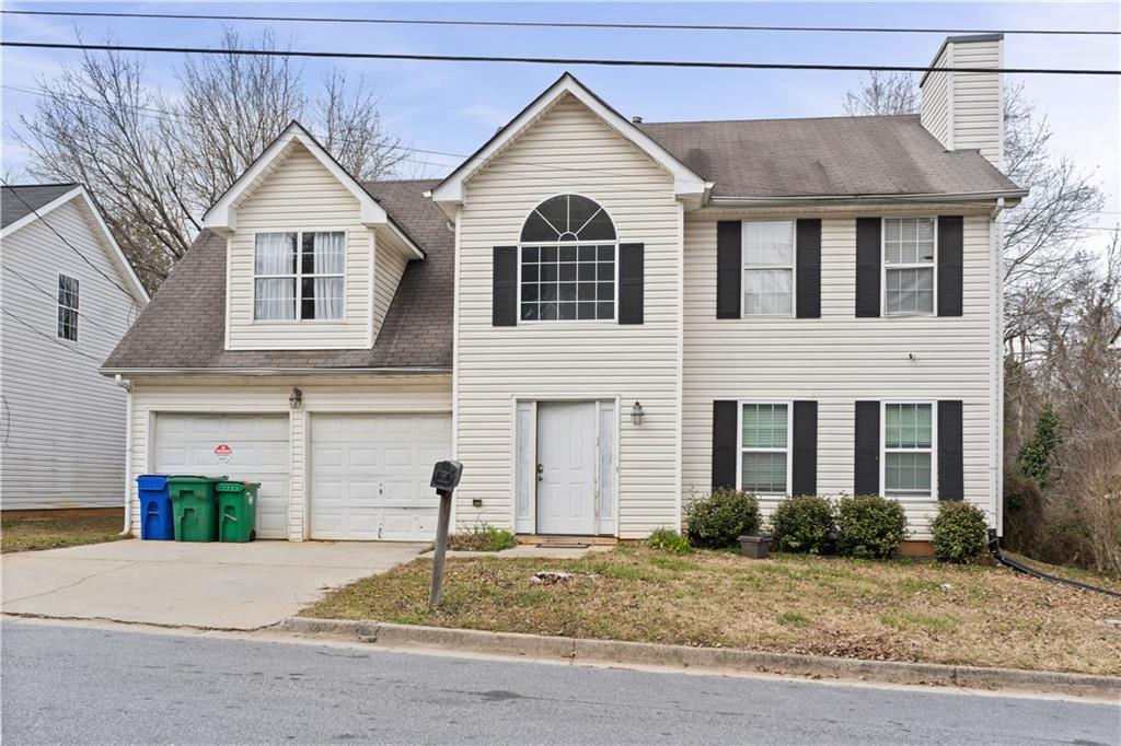 3958 Waldrop Hills Drive Decatur, GA 30034 - Photo 1 of 1 a view of a brick house with large windows and a yard with plants