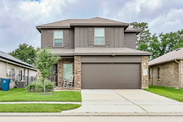 a front view of a house with a yard and garage