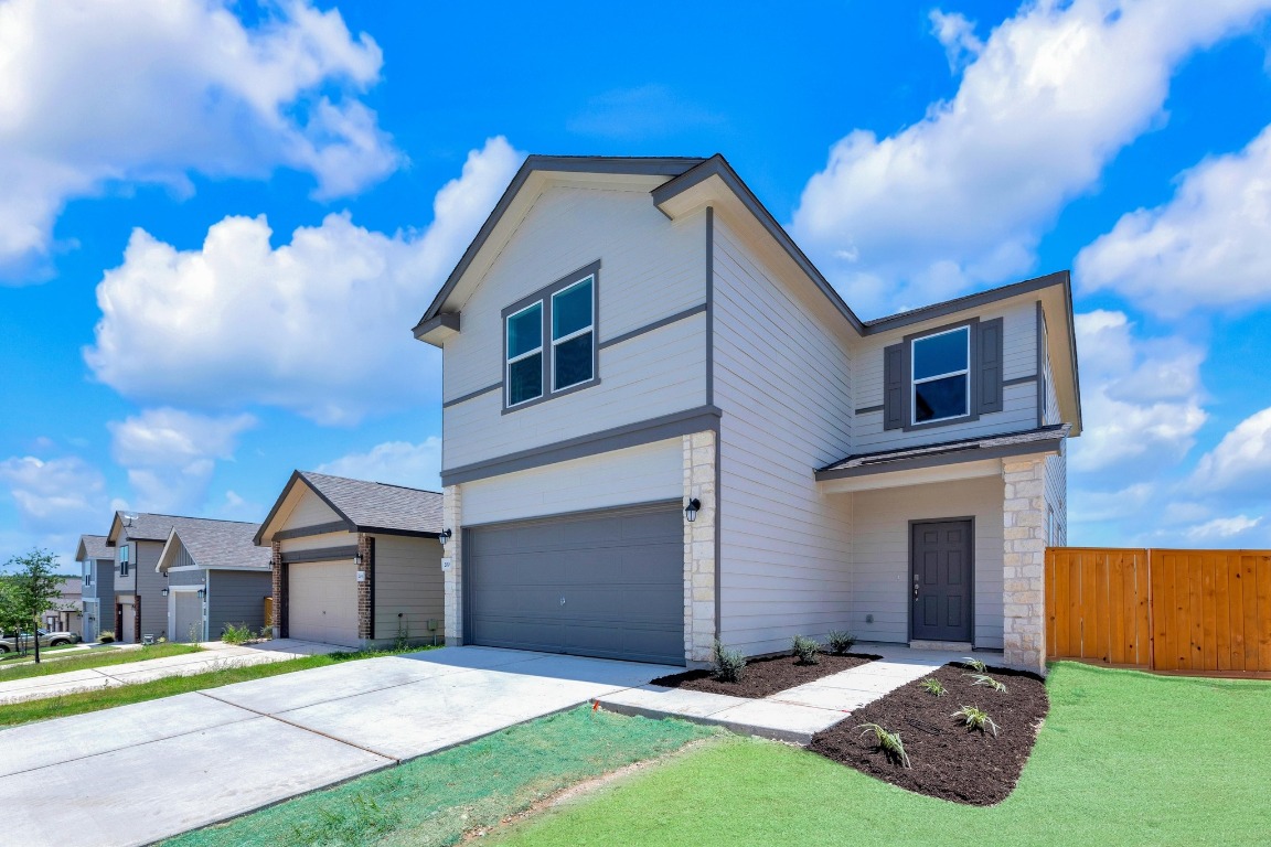 a front view of a house with a yard and garage