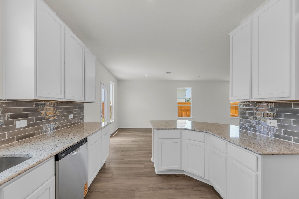 200 Lucky Texan Road Jarrell, TX 76537 - Photo 11 of 34 a kitchen with granite countertop white cabinets and a sink
