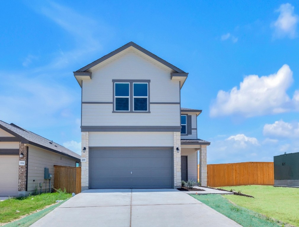 200 Lucky Texan Road Jarrell, TX 76537 - Photo 2 of 34 a front view of a house with a yard and garage
