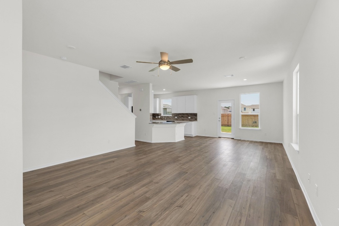 200 Lucky Texan Road Jarrell, TX 76537 - Photo 3 of 34 wooden floor in an empty room with a kitchen