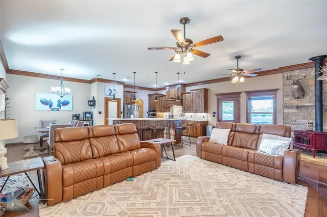 a living room with furniture kitchen view and a chandelier