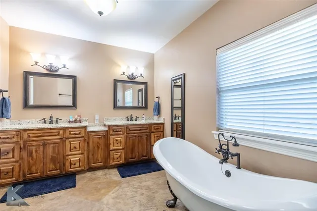 a spacious bathroom with a double vanity sink double mirror and bathtub