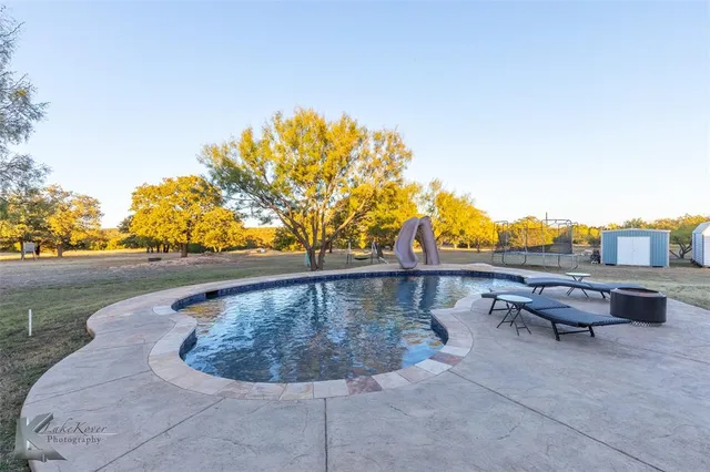a view of swimming pool with a yard and sitting space