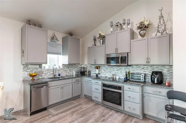 a kitchen with stainless steel appliances a sink stove and cabinets
