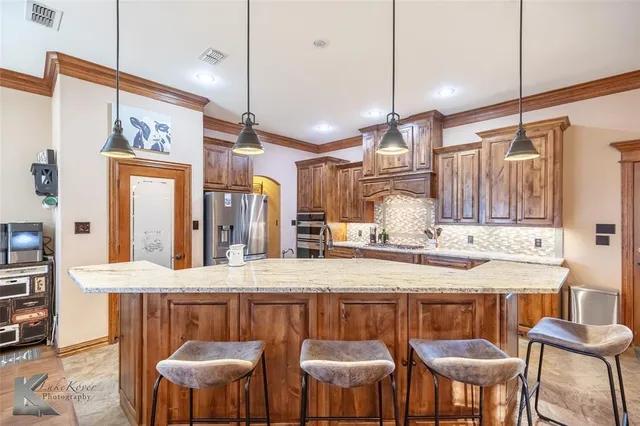 a kitchen with stainless steel appliances kitchen island a table and chairs