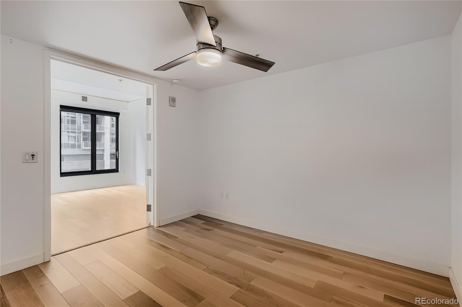 1750 Wewatta Street, Unit 403 Denver, CO 80202 - Photo 14 of 40 an empty room with wooden floor fan and window