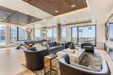a room with gym equipment pool table furniture and a large window