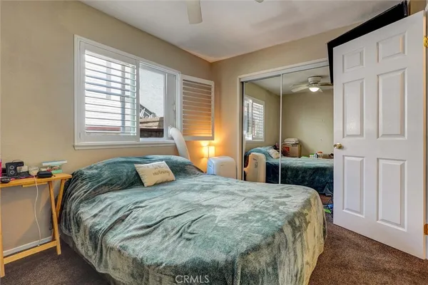 a bedroom with a bed and a dresser with mirror