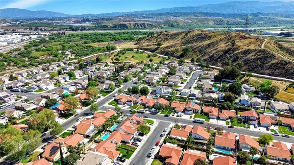 an aerial view of residential houses with outdoor space and trees