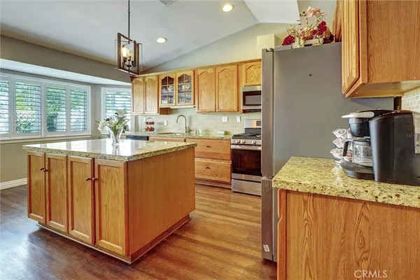 a kitchen with kitchen island granite countertop a sink stainless steel appliances and cabinets