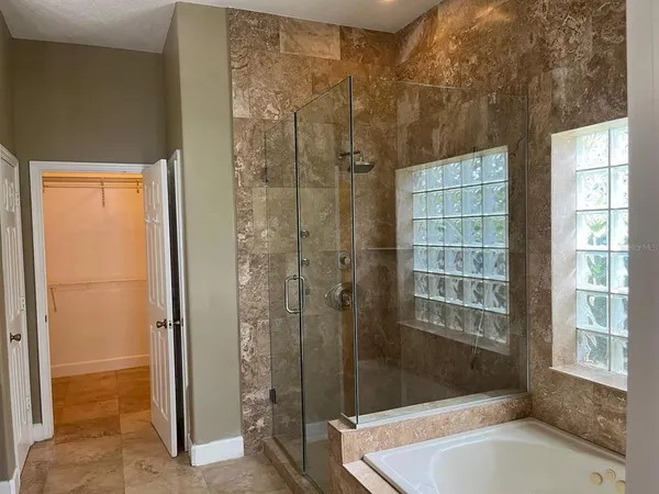 a bathroom with a tub shower and sink