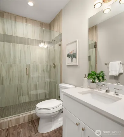 a bathroom with a sink a toilet and shower